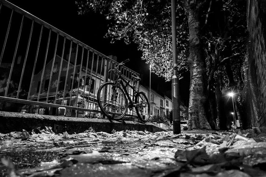 Bike locked to railings, autumn, leaves, rain, night, street, urban. Black and white urban street photography landscape, night and rain. Chatham Place Brighton UK. © P. Maton 2016 eyeteeth.net