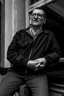Man in Harington jacket leaning on ledge in front of pub window torso length portrait black and white nightlife photograph. Shakespeare's Head pub Brighton UK. © P. Maton 2017 eyeteeth.net